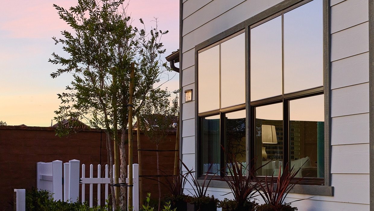 Home exterior with sunset reflecting in Ply Gem single hung windows with simulated divided lites.